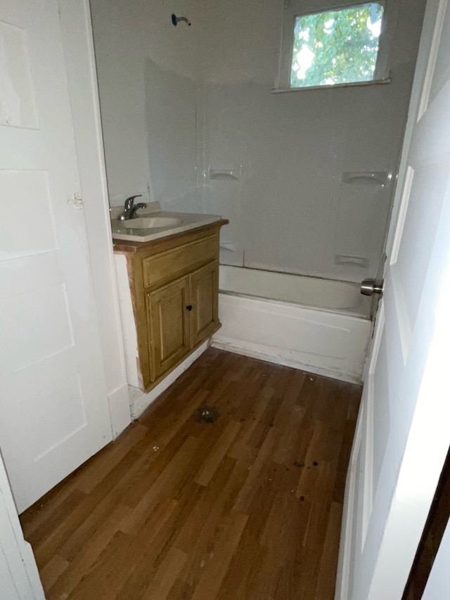 bathroom with vanity, hardwood / wood-style flooring, and shower / washtub combination