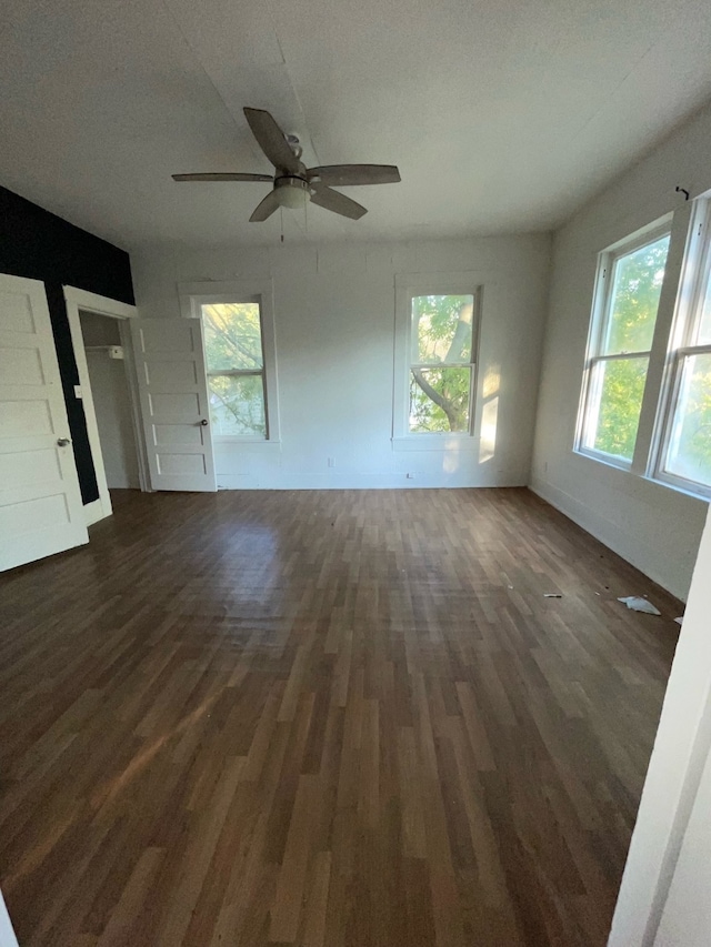 interior space with a textured ceiling, a healthy amount of sunlight, ceiling fan, and dark hardwood / wood-style flooring