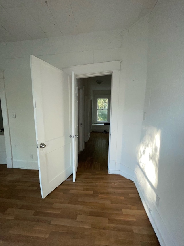 corridor with dark hardwood / wood-style flooring