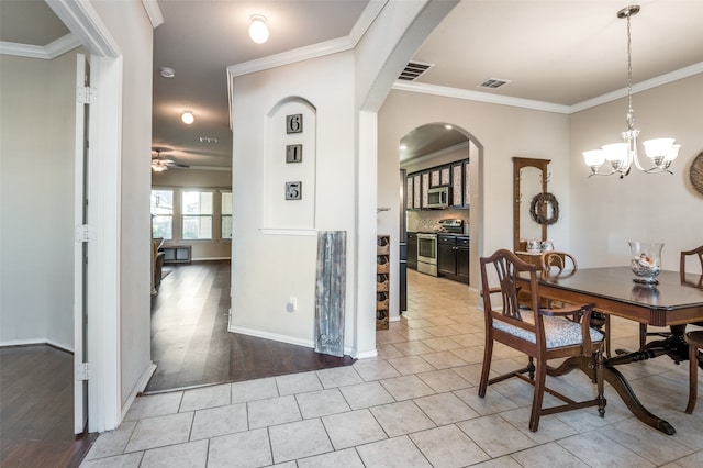 dining space with crown molding, ceiling fan with notable chandelier, and light wood-type flooring