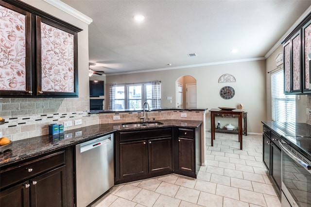 kitchen featuring ceiling fan, ornamental molding, dark stone countertops, sink, and stainless steel appliances