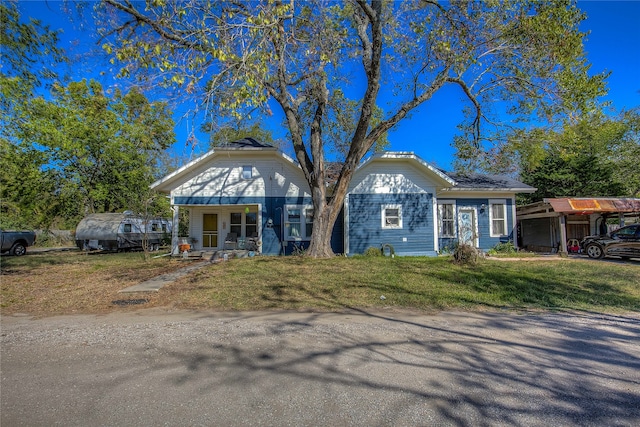 view of front of property featuring a front lawn, a carport, and a porch