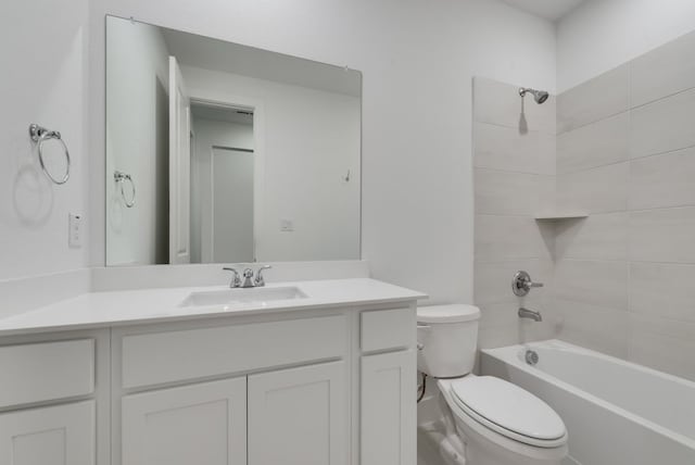 full bathroom with vanity, tiled shower / bath combo, and toilet