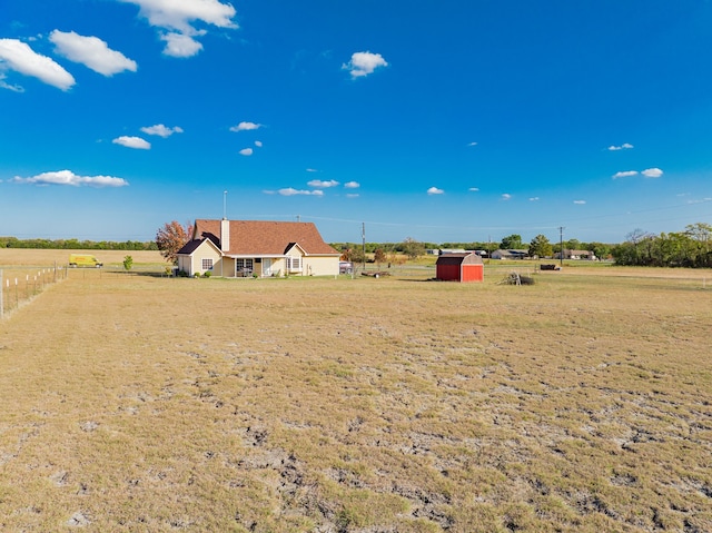 view of yard with a rural view and a shed