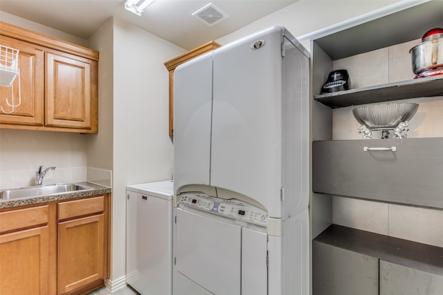 washroom with cabinets, sink, and washer and clothes dryer