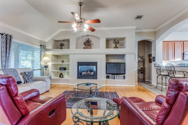 living room featuring crown molding, light hardwood / wood-style floors, built in features, and ceiling fan