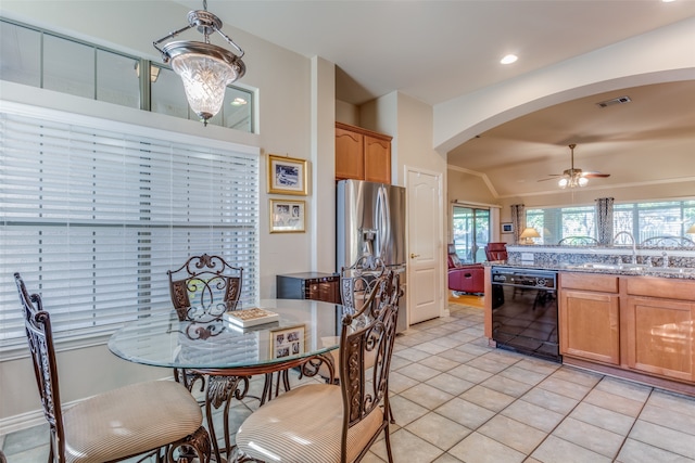 kitchen featuring lofted ceiling, black dishwasher, light tile patterned floors, stainless steel refrigerator with ice dispenser, and sink