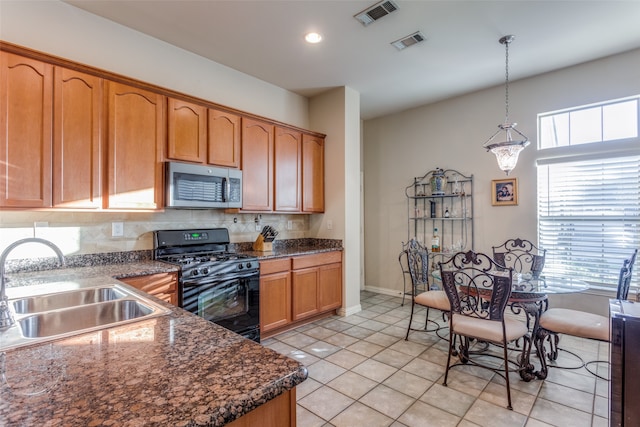 kitchen featuring decorative light fixtures, sink, plenty of natural light, and black gas stove