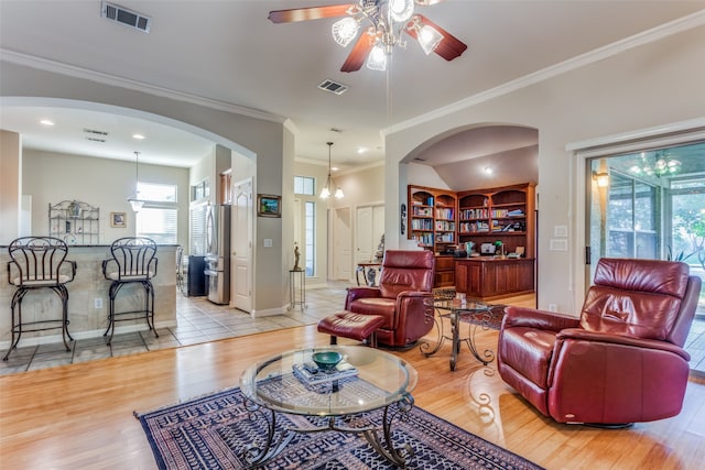 living room with ceiling fan, ornamental molding, and light hardwood / wood-style flooring