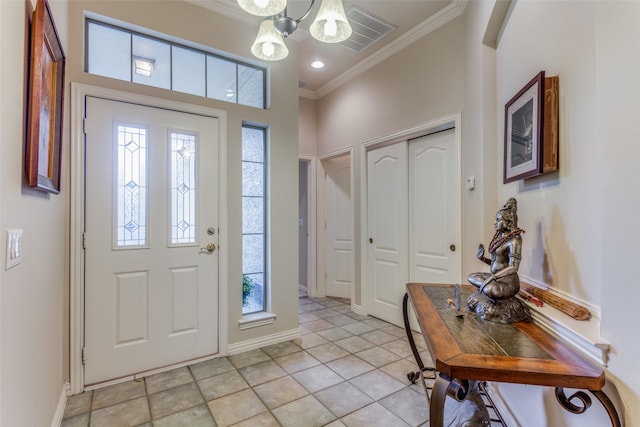 tiled foyer with crown molding and a notable chandelier