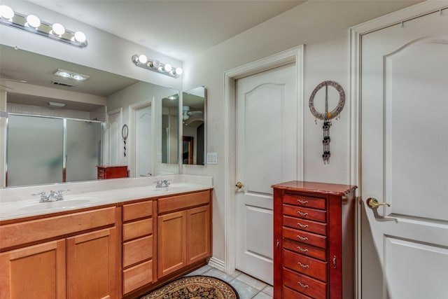 bathroom featuring a shower with door, vanity, and tile patterned flooring