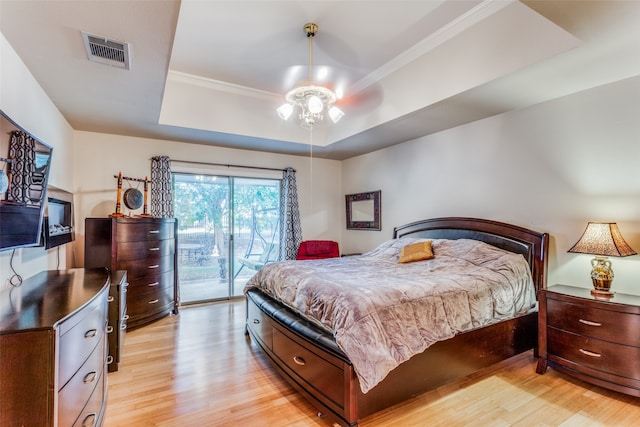 bedroom featuring access to exterior, light hardwood / wood-style flooring, ornamental molding, a raised ceiling, and ceiling fan