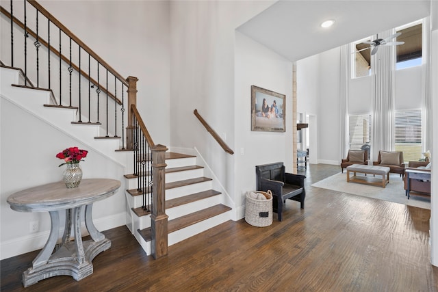 stairs featuring a towering ceiling and hardwood / wood-style flooring