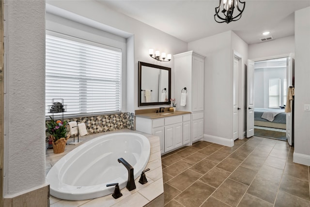 bathroom featuring vanity, a relaxing tiled tub, tile patterned floors, and a chandelier