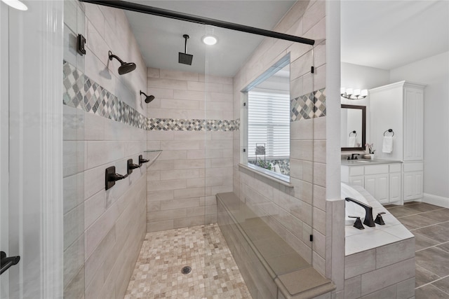 bathroom with a tile shower, vanity, and tile patterned flooring