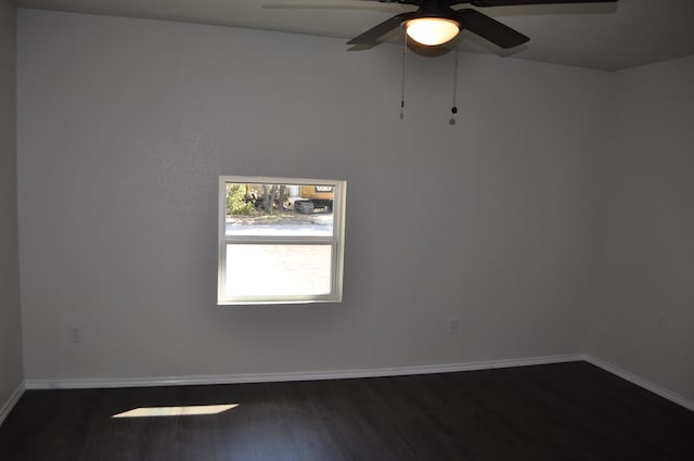 spare room featuring dark wood-type flooring and ceiling fan