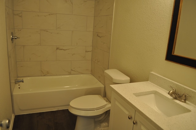 full bathroom featuring vanity, tiled shower / bath combo, and toilet