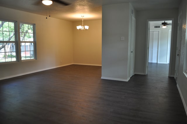 empty room with dark hardwood / wood-style floors and an inviting chandelier