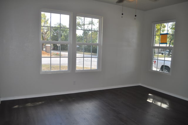 unfurnished room with ceiling fan, a healthy amount of sunlight, and dark hardwood / wood-style floors