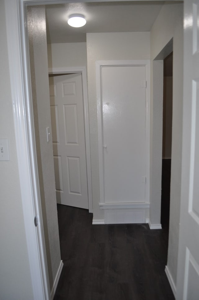 hallway with dark hardwood / wood-style flooring