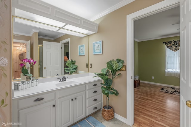 bathroom with ornamental molding, wood-type flooring, and vanity