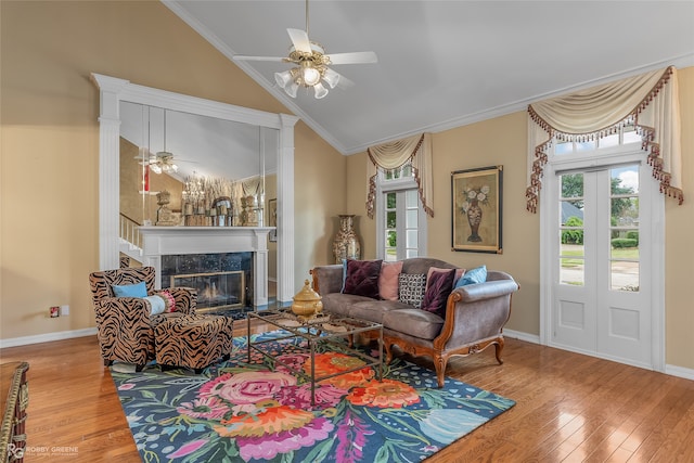 living room featuring a fireplace, crown molding, hardwood / wood-style floors, vaulted ceiling, and ceiling fan