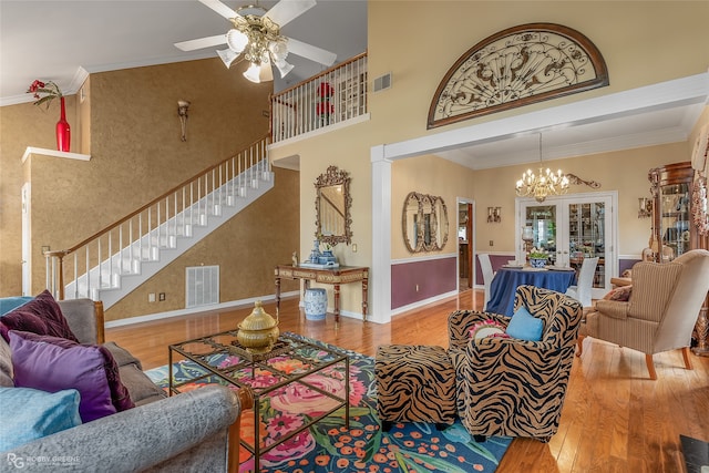 living room featuring french doors, ornamental molding, ornate columns, hardwood / wood-style floors, and ceiling fan with notable chandelier