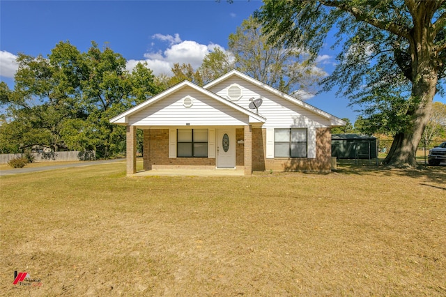 bungalow featuring covered porch, a front lawn, and brick siding