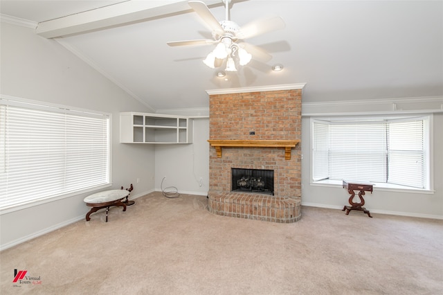 carpeted living room with crown molding, a brick fireplace, vaulted ceiling with beams, and ceiling fan