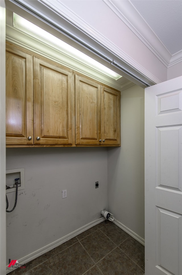 laundry area featuring cabinets, hookup for an electric dryer, hookup for a washing machine, dark tile patterned flooring, and crown molding