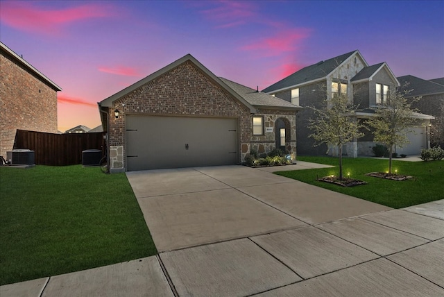 view of front of home featuring central AC, a lawn, and a garage