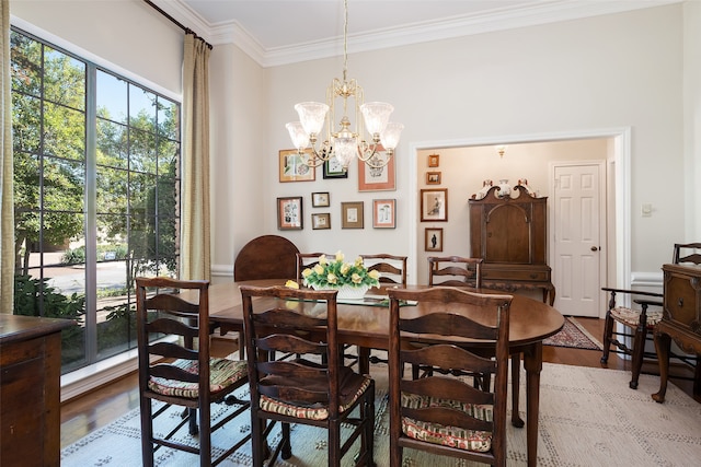 dining room with a wealth of natural light, crown molding, light hardwood / wood-style floors, and a chandelier