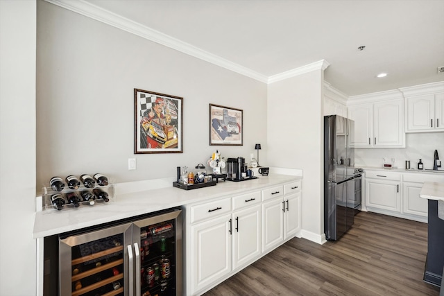 kitchen featuring beverage cooler, white cabinetry, dark hardwood / wood-style floors, crown molding, and sink