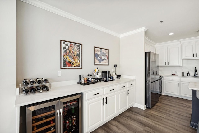 bar featuring crown molding, a bar, dark wood-style floors, recessed lighting, and wine cooler
