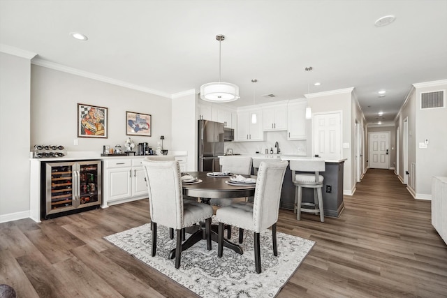 dining room featuring crown molding, wet bar, dark hardwood / wood-style floors, and beverage cooler