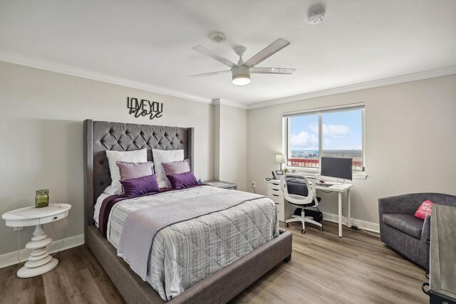 bedroom with wood finished floors, a ceiling fan, ornamental molding, and baseboards