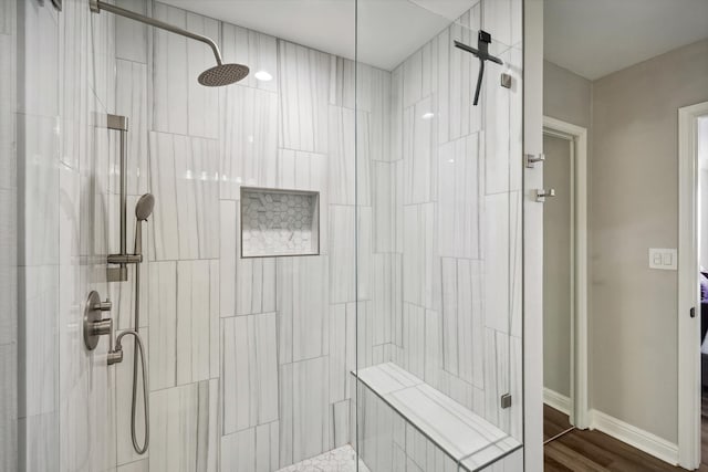 bathroom featuring a tile shower and hardwood / wood-style floors