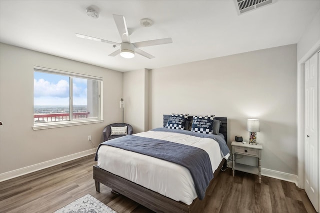 bedroom with a closet, dark wood-type flooring, and ceiling fan