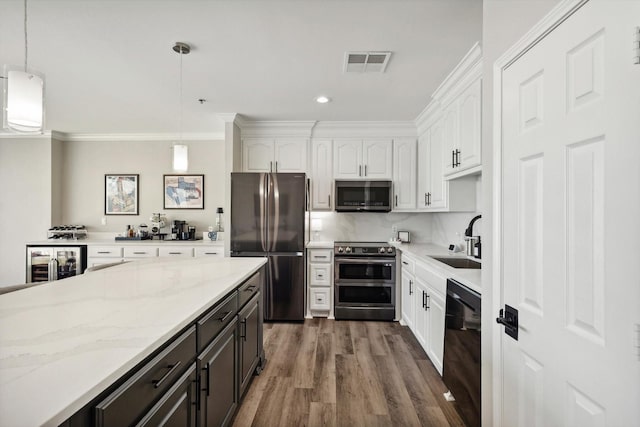 kitchen featuring appliances with stainless steel finishes, visible vents, white cabinets, and a sink