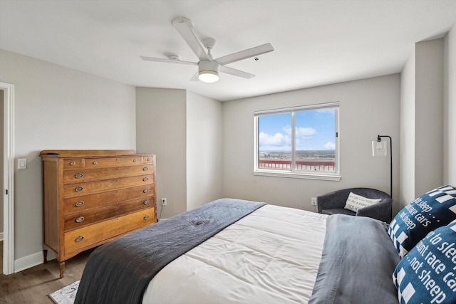 bedroom featuring a ceiling fan, wood finished floors, and baseboards