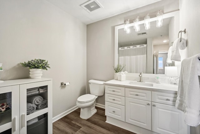 bathroom with toilet, vanity, wood-type flooring, and a shower with shower curtain