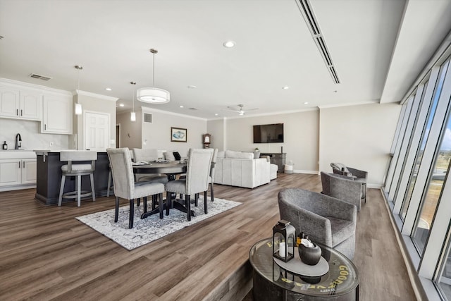 dining area featuring ornamental molding, sink, hardwood / wood-style flooring, and ceiling fan