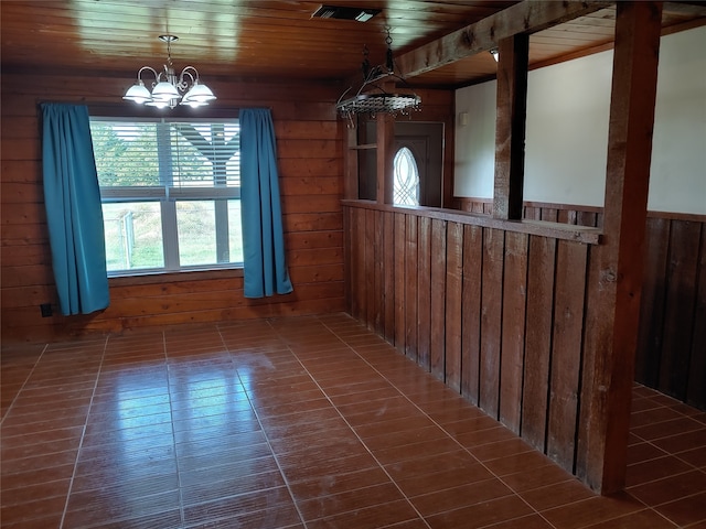 unfurnished dining area featuring wood ceiling, dark tile patterned floors, and wooden walls