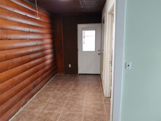 hall featuring light tile patterned flooring and rustic walls