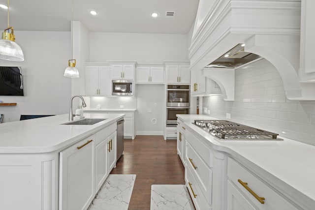 kitchen featuring hanging light fixtures, appliances with stainless steel finishes, white cabinetry, dark hardwood / wood-style floors, and sink