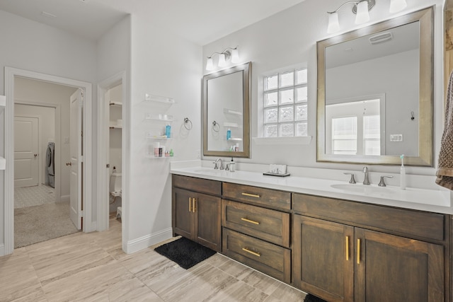 bathroom with vanity, toilet, and washer / dryer