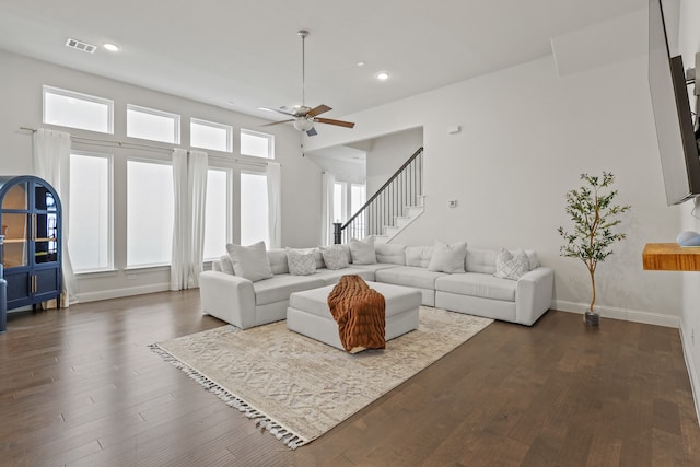 living room featuring dark wood-type flooring and ceiling fan