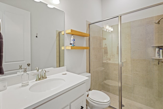 bathroom featuring vanity, toilet, and an enclosed shower