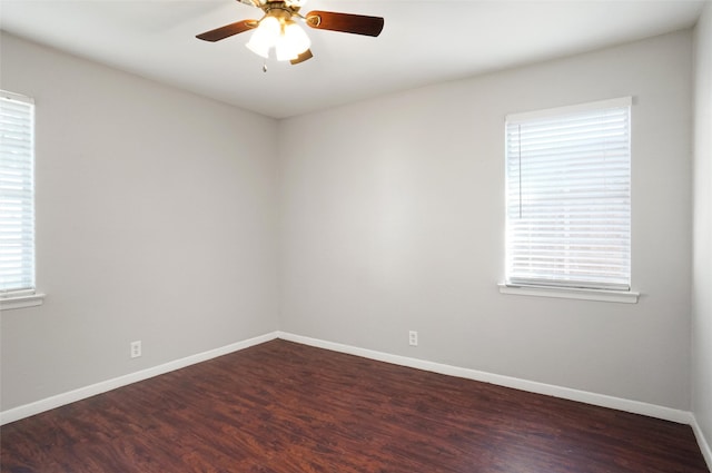 empty room with dark hardwood / wood-style floors and ceiling fan