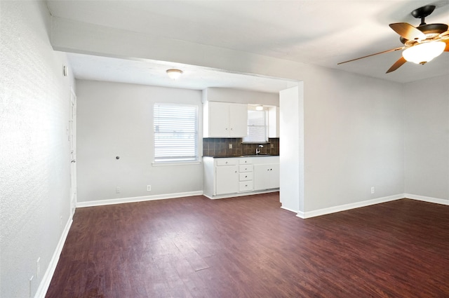 unfurnished living room featuring ceiling fan and dark hardwood / wood-style flooring